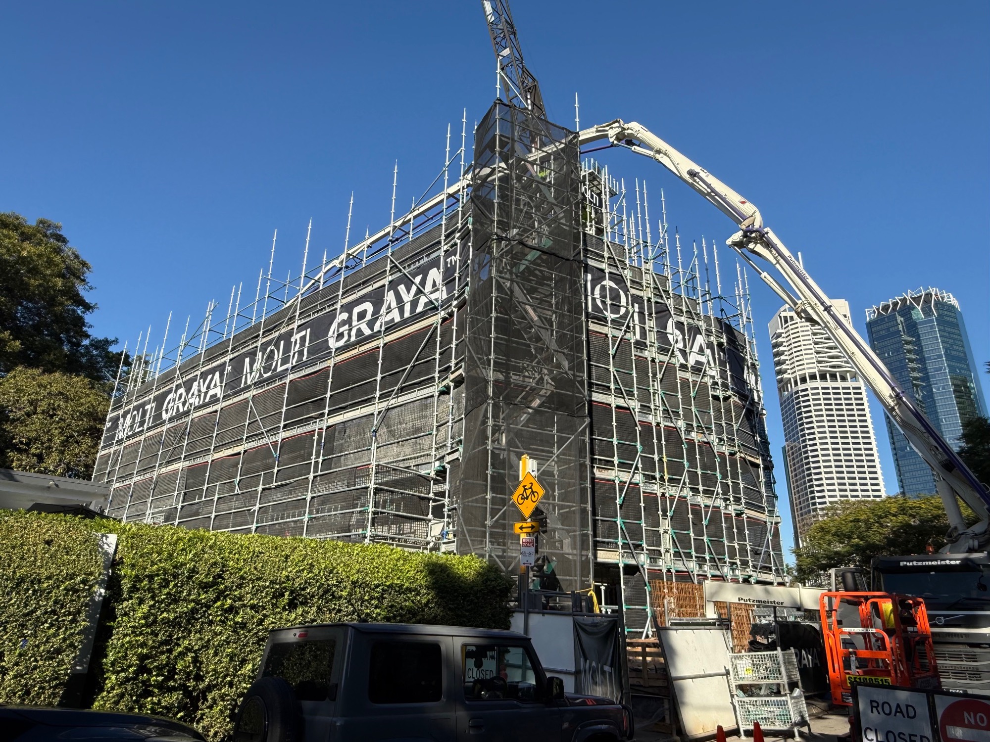 Heirloom under scaffold from MacDonald Street, with the Brisbane CBD beyond